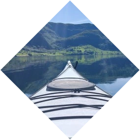 kayak on a mirror-glass fjord surrounded by mountains